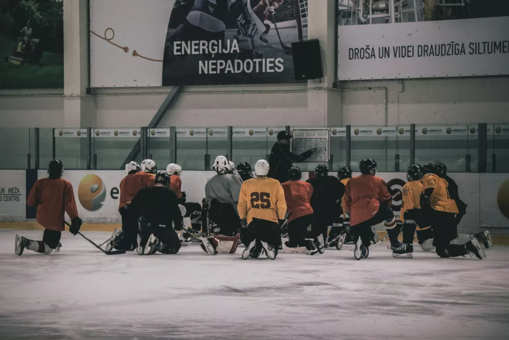 A hockey coach giving instructions to players during practice.